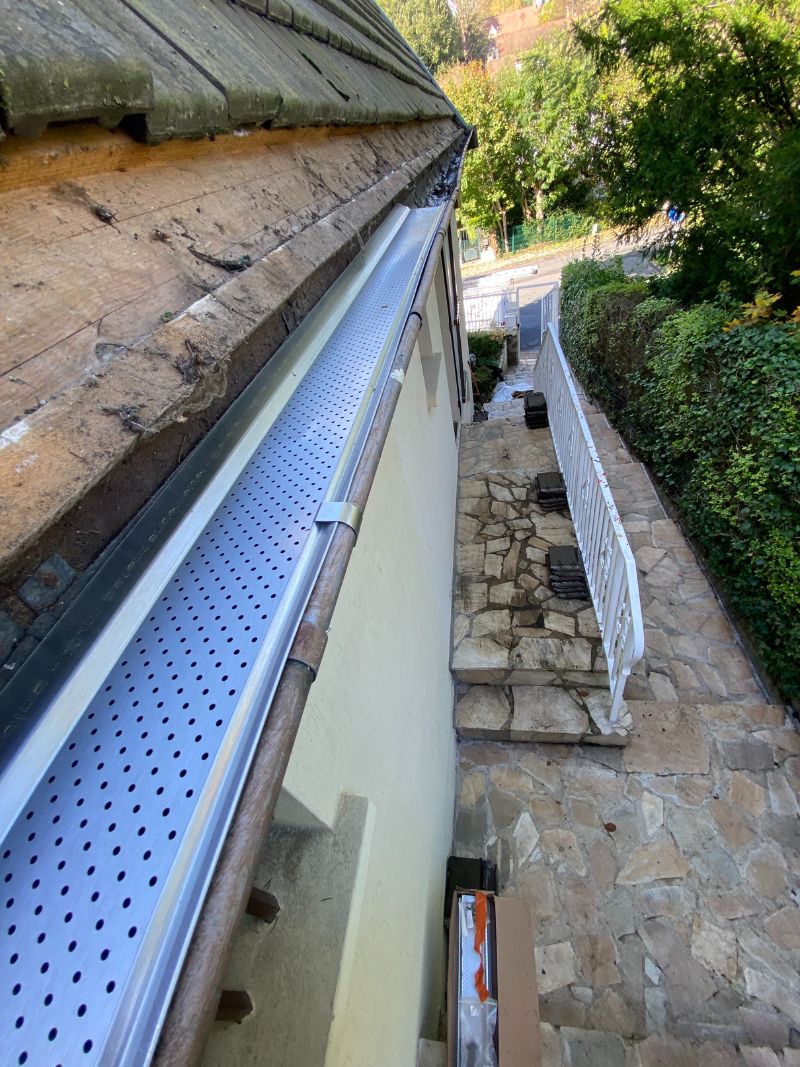 Pose pare-feuilles aluminium en cours sur gouttière Saint-Germain-en-Laye