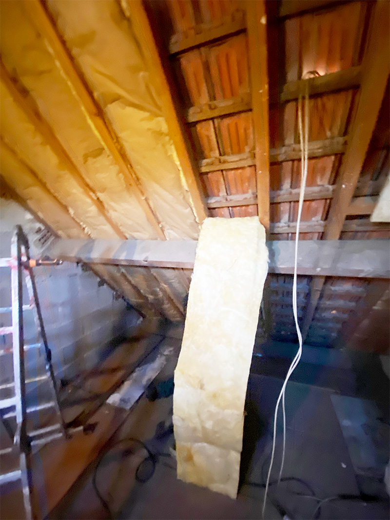 Pose de la première couche de laine de verre dans les combles perdus